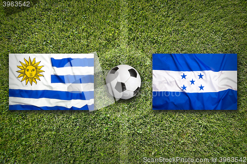 Image of Uruguay vs. Honduras flags on soccer field