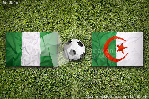 Image of Nigeria vs. Algeria flags on soccer field
