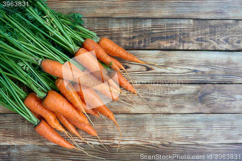 Image of Fresh carrots bunch on rustic wooden background