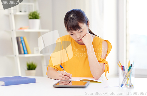 Image of bored asian woman student with tablet pc at home