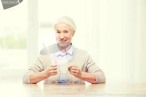 Image of happy senior woman with cup of tea or coffee