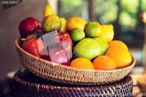 Image of basket of fresh ripe juicy fruits at kitchen