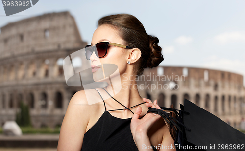 Image of happy woman in black sunglasses with shopping bags