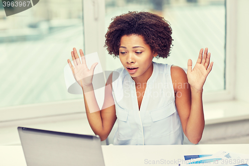 Image of african woman with laptop at office