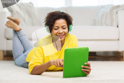 Image of happy african woman with tablet pc and headphones