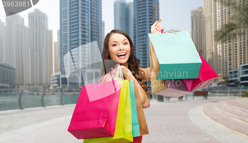 Image of happy woman with shopping bags over dubai city