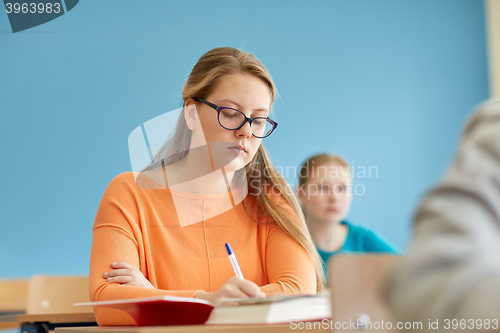 Image of group of students with books writing school test