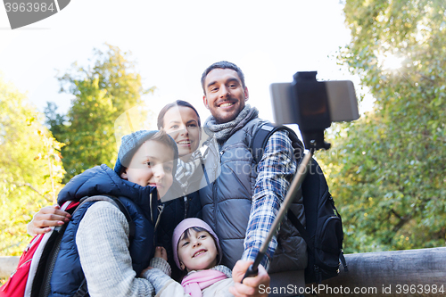 Image of family with backpacks taking selfie and hiking