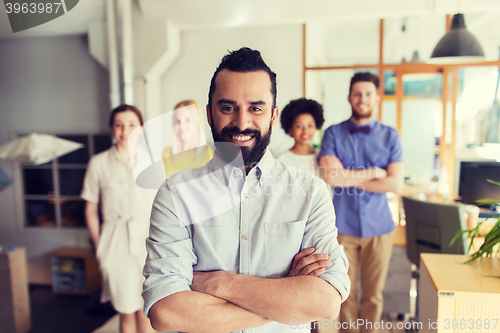 Image of happy young man over creative team in office