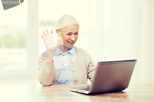 Image of senior woman with laptop having video chat at home