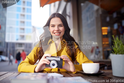 Image of happy tourist woman with camera at city cafe