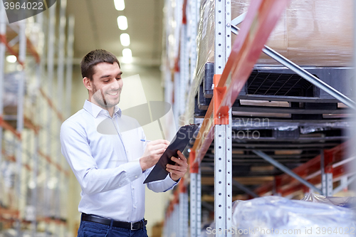 Image of happy businessman with clipboard at warehouse