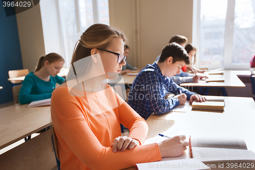 Image of group of students with books writing school test