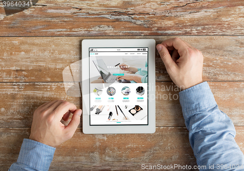 Image of close up of male hands to tablet pc on table