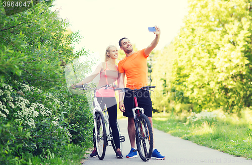 Image of couple with bicycle taking selfie by smartphone