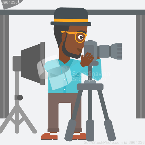 Image of Photographer working with camera on a tripod.