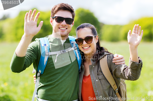 Image of happy couple with backpacks hiking outdoors