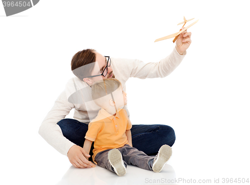 Image of father and little son playing with toy airplane