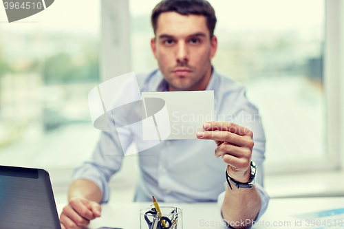 Image of businessman showing blank paper card at office