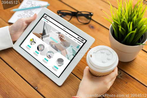 Image of close up of woman with tablet pc on wooden table