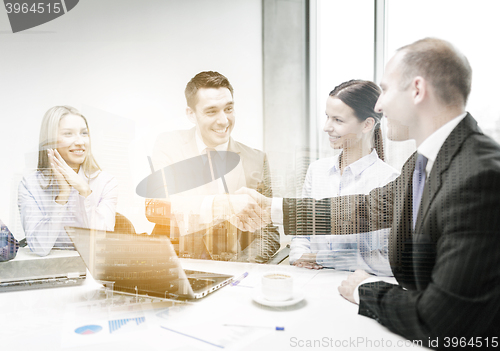 Image of two businessman shaking hands in office