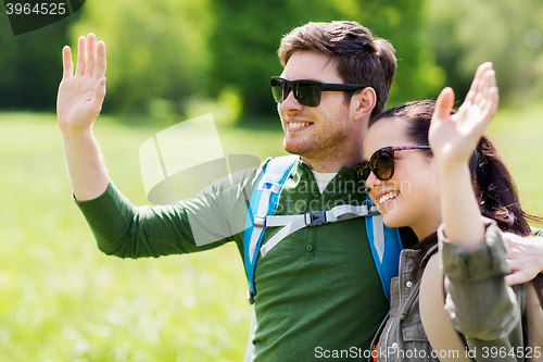 Image of happy couple with backpacks hiking outdoors