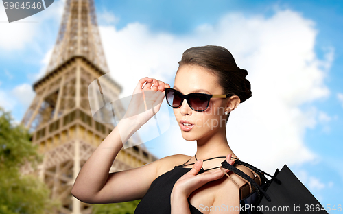 Image of happy woman in black sunglasses with shopping bags