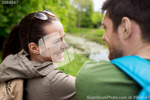 Image of smiling couple with backpacks in nature