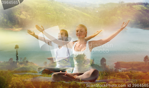 Image of smiling couple making yoga exercises outdoors