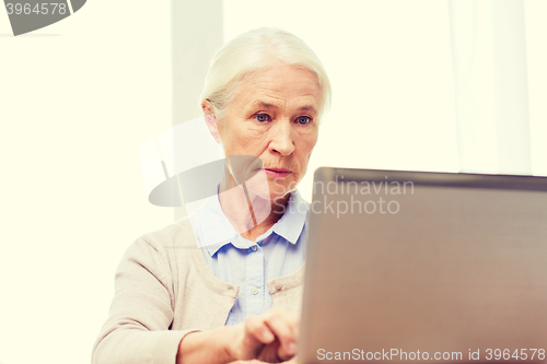 Image of senior woman with laptop at home