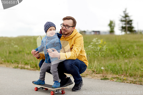 Image of happy father and little son on skateboard