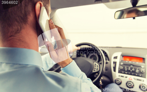 Image of close up of man with smartphone driving car