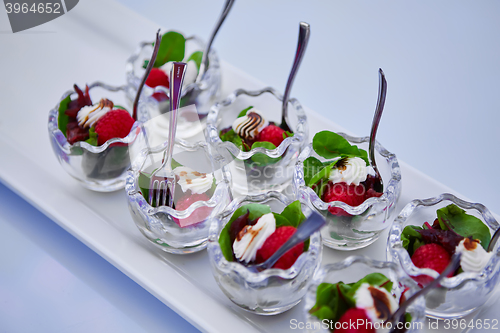 Image of appetizer with cream cheese, raspberry and beet leaves