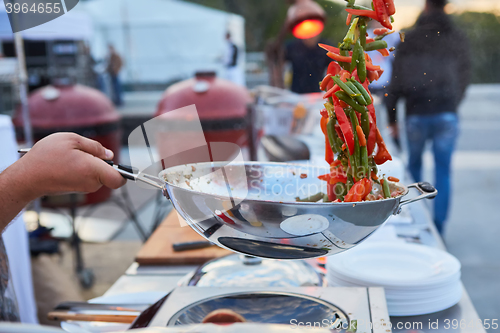 Image of chef tossing vegetables in a wok