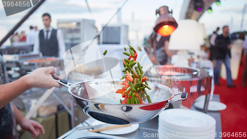 Image of chef tossing vegetables in a wok
