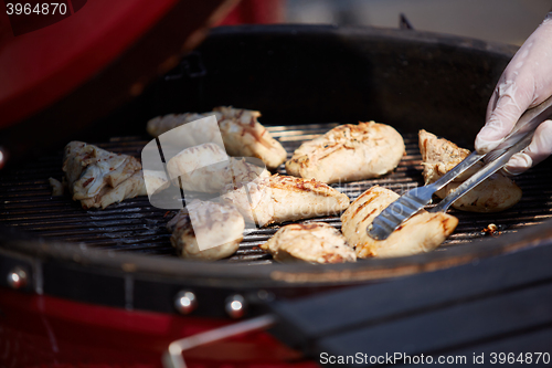 Image of thick strip steak being grilled outdoors. Shallow dof