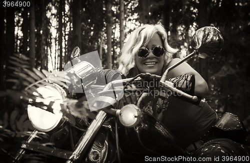Image of Mature woman biker on a motorcycle in sepia