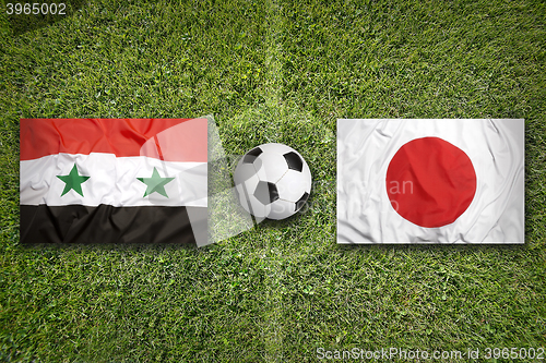 Image of Iraq vs. Japan flags on soccer field