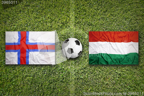 Image of Faeroe Islands vs. Hungary flags on soccer field
