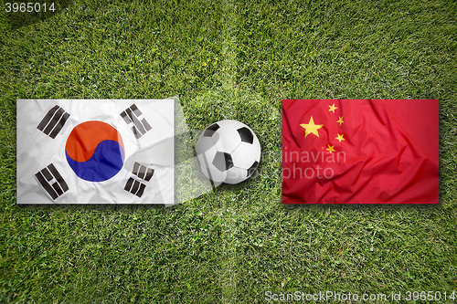 Image of South Korea vs. China flags on soccer field