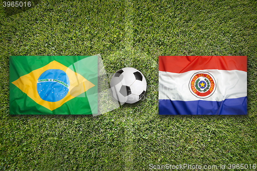 Image of Brazil vs. Paraguay flags on soccer field