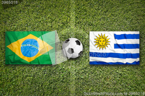 Image of Brazil vs. Uruguay flags on soccer field