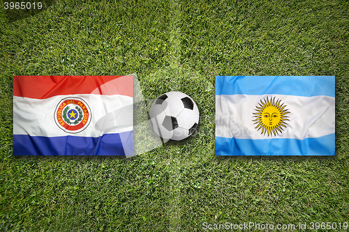 Image of Paraguay vs. Argentina flags on soccer field