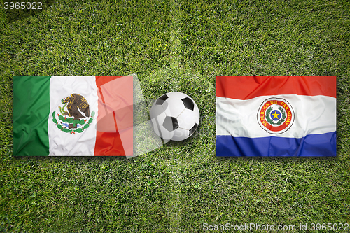 Image of Mexico vs. Paraguay flags on soccer field