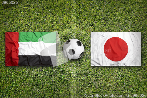 Image of United Arab Emirates vs. Japan flags on soccer field
