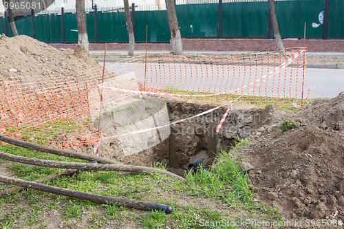 Image of Dug pit fenced for replacing electric cables underground