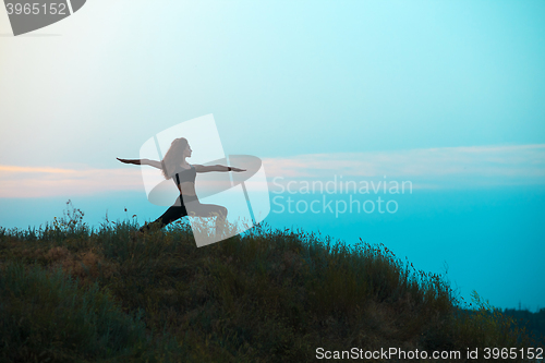 Image of The silhouette of young woman is practicing yoga
