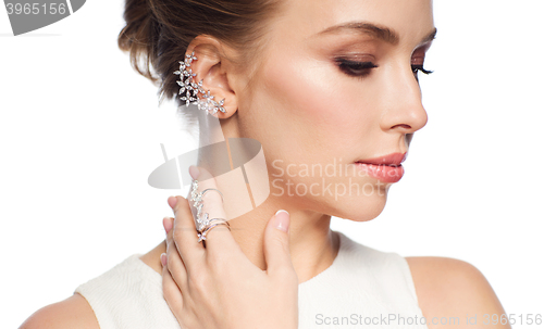 Image of smiling woman in white dress with diamond jewelry