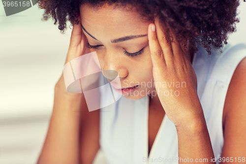 Image of close up of african young woman touching her head
