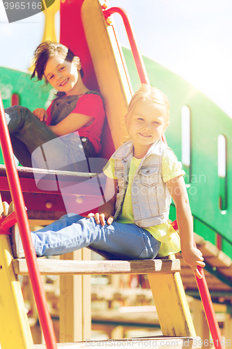 Image of happy kids or children on playground slide